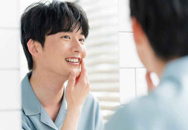 鏡で歯並びを確認する男性